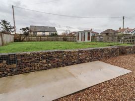 A garden with grass, gravel and a shed at Braeburn in Bamburgh