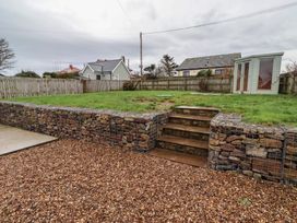 A garden with a stone wall and steps at Braeburn in Bamburgh