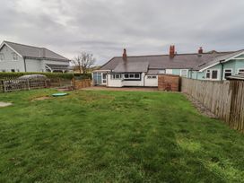 A garden with grass and houses in the background at Braeburn in Bamburgh