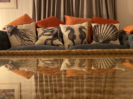 A couch with decorative pillows at Braeburn in Bamburgh