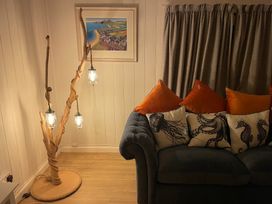 A living room with a sofa and decorative pillows at Braeburn in Bamburgh