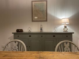 A dining room with a sideboard and lamp at Braeburn in Bamburgh