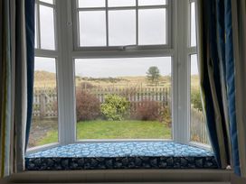 A window with a cushion overlooking a garden at Braeburn in Bamburgh