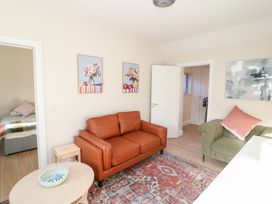 A living room with a brown sofa and rug at Duck Cottage