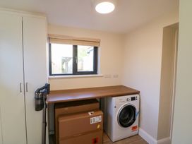 A laundry room with a washing machine and a worktop at Duck Cottage
