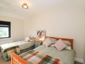 A bedroom with two beds and a window at Duck Cottage