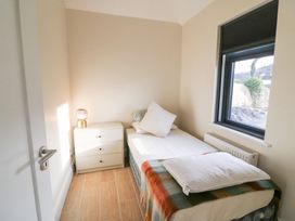 A bedroom with a bed and a bedside table at Duck Cottage