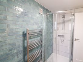 A bathroom with a shower and towel radiator at Duck Cottage
