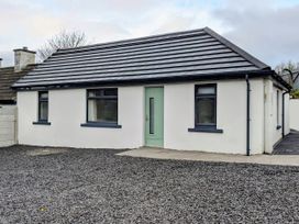 A house with a green door and gravel driveway at Duck Cottage in Caherciveen, County Kerry