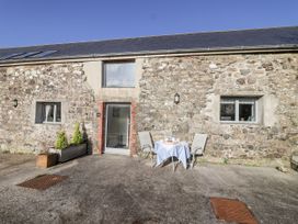 An outdoor area with a table and chairs at Dairy Cottage Bullhornstone near South Brent