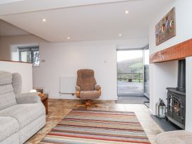 A living room with a sofa and a fireplace at Dairy Cottage in Bullhornstone near South Brent