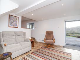 A snug with a sofa and armchair at Dairy Cottage in Bullhornstone near South Brent