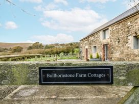 Sign for Bullhornstone Farm Cottages with cottages and hills in the background at Dairy Cottage Bullhornstone near South Brent