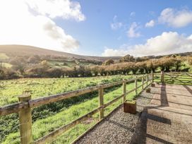 A view of hills and a grassy field with a fence at Dairy Cottage in Bullhornstone near South Brent