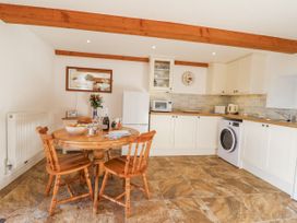A kitchen with a table and chairs at Swallow Cottage Bullhornstone near South Brent