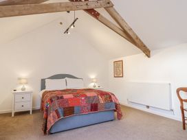 A bedroom with a bed and bedside table at Swallow Cottage near South Brent