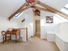 A loft space with a writing desk and chair at Swallow Cottage Bullhornstone near South Brent