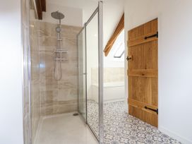 A bathroom with a shower and a bathtub at Swallow Cottage Bullhornstone near South Brent