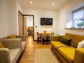 A living room with a dining table and sofa at Aspen Apartment in Llanrwst