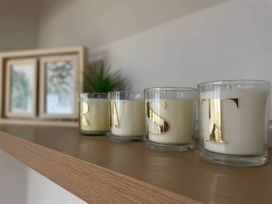A shelf with candles and framed pictures at Aspen Apartment in Llanrwst