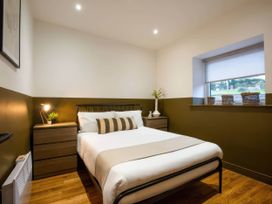 A bedroom with a bed and nightstands at Aspen Apartment in Llanrwst