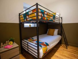 A bunk bed with a ladder and a shelf in a bedroom at Aspen Apartment in Llanrwst