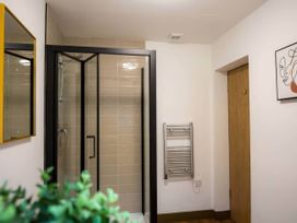 A bathroom with a shower and a towel rail at Aspen Apartment in Llanrwst