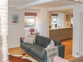 A living room featuring a sofa and kitchen area at The Old Workshop in 