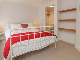 A bedroom with a bed and shelves at The Old Workshop