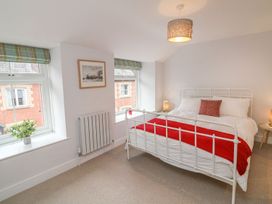 A bedroom with a bed and windows at The Old Workshop in 