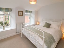A bedroom with a bed and windows at The Old Workshop in 