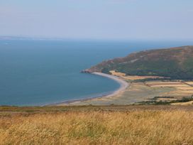 A beach and sea view with hills in the background at The Old Workshop in 
