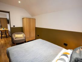 A bedroom with a bed and wardrobe at White Willow Apartment in Llanrwst