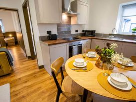 A kitchen with a dining area and appliances at Oakwood Apartment Llanrwst
