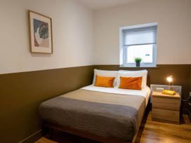 A bedroom with a bed and nightstand at Oakwood Apartment Llanrwst