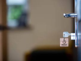 A door handle with a key and key tag at Oakwood Apartment, Llanrwst