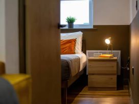 A bedroom with a bed and nightstand at Oakwood Apartment Llanrwst