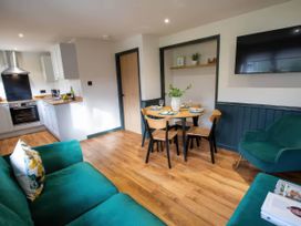 A living room with a kitchen and dining area at Ash Cottages in Llanrwst
