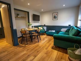 A living room with a dining table and sofa at Ash Cottages Llanrwst