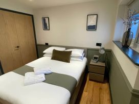A bedroom with a bed and bedside table at Ash Cottages in Llanrwst