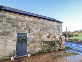 An exterior view of a stone building with a door and a gate at Chestnut Barn in Aislaby near Whitby