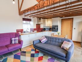 A living room with a kitchen area and seating at Chestnut Barn Aislaby near Whitby