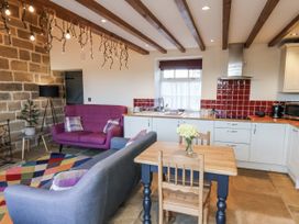 A kitchen with a dining table and sofa at Chestnut Barn Aislaby near Whitby