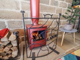 A living room with a fireplace and a small table at Chestnut Barn Aislaby near Whitby
