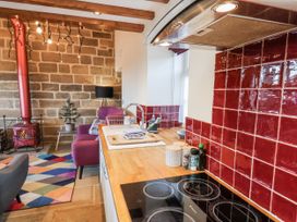 A kitchen with stove and kitchen island at Chestnut Barn Aislaby near Whitby