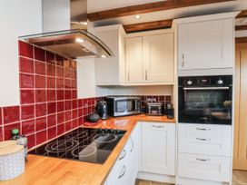 A kitchen with cabinets and appliances at Chestnut Barn Aislaby near Whitby