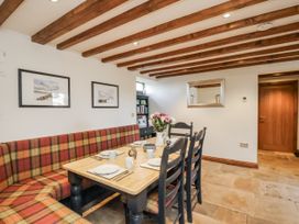 A dining room with a table and chairs at Chestnut Barn Aislaby near Whitby