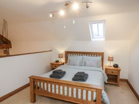 A bedroom with a bed and nightstands at Chestnut Barn Aislaby near Whitby