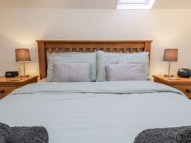 A bedroom with a bed and bedside lamps at Chestnut Barn Aislaby near Whitby