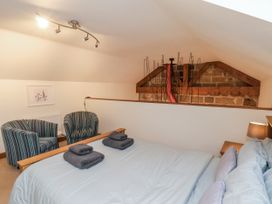 A bedroom with a bed and chairs at Chestnut Barn Aislaby near Whitby